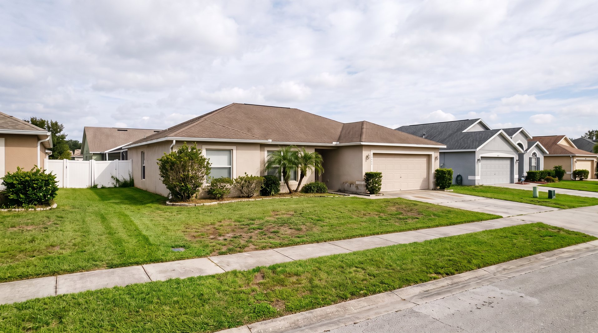 Clean and orderly Central Florida home after exterior cleanup, with cleared beds, trimmed shrubs and a swept walkway